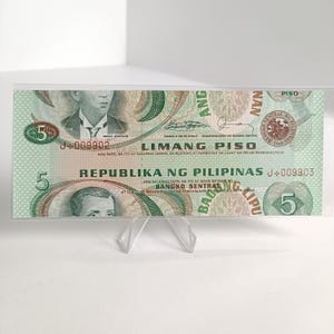 Könnte beinhalten: Eine philippinische Fünf-Peso-Banknote, überwiegend grün, mit Porträts historischer Persönlichkeiten und dem Text "Republika ng Pilipinas". Die Note trägt den Text "Limang Piso" und das Siegel der Bangko Sentral ng Pilipinas.
