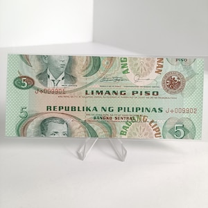 Könnte beinhalten: Ein philippinischer Fünf-Peso-Geldschein, überwiegend grün, mit Porträts historischer Persönlichkeiten und dem Text "Republika ng Pilipinas". Die Banknote zeigt den Wert "5" an mehreren Stellen und weist detaillierte Designs und Text auf.