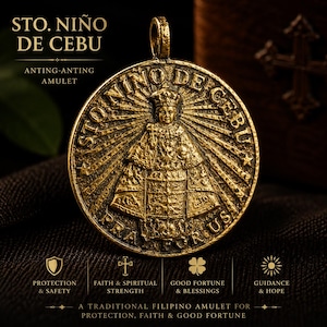 Pode incluir: Um pingente circular de metal dourado com um relevo do Sto. Niño de Cebu. O texto diz STO. NIÑO DE CEBU e PRAY FOR US. O design inclui uma figura central com coroa e vestes, cercada por linhas radiantes e estrelas.