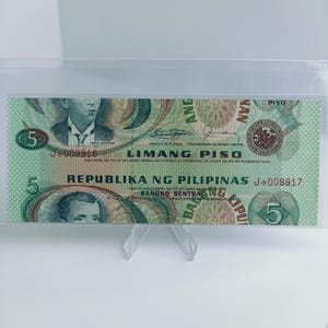 May include: A green and brown Philippine 5 Piso banknote with a portrait of Andres Bonifacio, the text "LIMANG PISO" and "REPUBLIKA NG PILIPINAS", and the seal of the Bangko Sentral ng Pilipinas.
