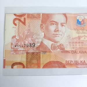 Op de afbeelding: Een Filipijnse bankbiljet van twintig peso met een portret van een man in een pak en een vlinderdas. De biljet heeft de tekst "REPUBLIKA NG PILIPINAS" en het serienummer WN547989. Het jaar 2012 is zichtbaar.