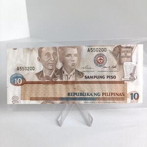 Op de afbeelding: Een 10 peso biljet uit de Filipijnen, gedateerd 1967, met portretten van Apolinario Mabini en Andres Bonifacio. Het biljet heeft de tekst "Republika ng Pilipinas" en "Sampung Piso" erop gedrukt.