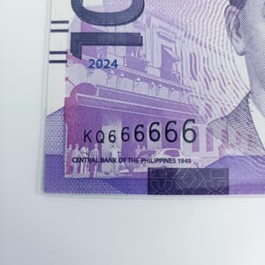 Könnte beinhalten: Eine Nahaufnahme eines philippinischen Banknotens in Lila und Weiß mit der Seriennummer "KQ666666" und dem Jahr "2024" darauf gedruckt. Die Zentralbank der Philippinen 1949 ist unten auf dem Schein gedruckt.