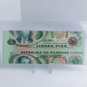 Könnte beinhalten: Eine philippinische Fünf-Peso-Banknote, überwiegend grün, mit Porträts historischer Persönlichkeiten und aufwendigen Designs. Der Text enthält "Limang Piso" und "Republika ng Pilipinas".