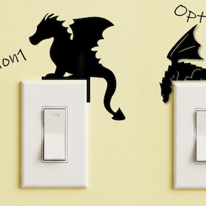 May include: Two black dragon-shaped light switch covers. Option 1 shows a dragon sitting on the switch, and Option 2 shows a dragon hanging down. The text "Option 1" and "Option 2" are written above the switches.
