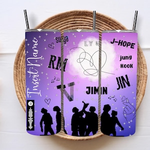 May include: Three purple and white insulated tumblers with images of the members of the K-Pop group BTS. The tumblers feature the names "RM", "Jimin", and "J-Hope" with the text "Jung Kook" and "Jin".