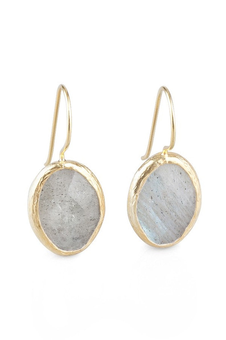 May include: A pair of gold earrings with a round, iridescent labradorite stone set in a textured gold bezel.
