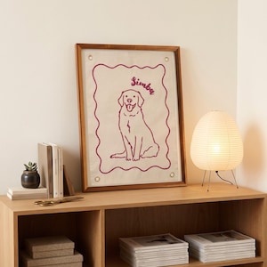 以下が含まれることがあります： 「Simba」という名前が筆記体で書かれた犬の線画が描かれた額入りのアートワーク。 アートワークは木製のフレームに入っており、紙のランタンランプが付いた木製の棚に飾られています。