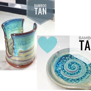 May include: Two handmade ceramic dishware pieces in a blue and tan glaze. The first piece is a dish with a swirl pattern. The second piece is a sponge holder with a rectangular opening. Both pieces are labeled "Bamboo Tan".