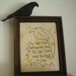 May include: A framed embroidery with a black crow perched on top. The embroidery features a stylized crow with the text "The Olde Crow watches over thee The Olde Crow sends blessings to thee".