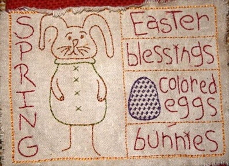 Peut inclure: Un panneau en tissu beige avec des images brod&eacute;es d'un lapin, d'un &oelig;uf et les mots "Printemps", "B&eacute;n&eacute;dictions de P&acirc;ques", "&oelig;ufs color&eacute;s" et "lapins".