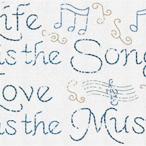 May include: Blue and brown embroidered quote on a white background. The quote reads "Life is the song, Love is the music."