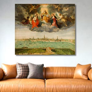 May include: A framed Renaissance-style painting shows a celestial scene above a coastal city. Angels and figures in robes are surrounded by clouds. The city features buildings and waterways, with boats on the water. The artwork is displayed above a brown leather sofa.