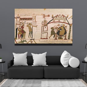 Könnte beinhalten: Eine Tapisserie, die eine Szene aus dem Bayeux-Teppich zeigt, einer historischen Stickerei, die die Geschichte der normannischen Eroberung Englands erzählt. Die Tapisserie zeigt Figuren in mittelalterlicher Kleidung, darunter einen König, der auf einem Thron sitzt, und eine Gruppe von Menschen, die vor einem Schloss stehen. Die Tapisserie ist gerahmt und an einer Wand ausgestellt.