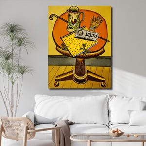 Peut inclure: Une peinture représentant une table ronde au plateau jaune sur un pied central. Sur la table sont posés une cruche ornée d'un coq, un gant beige et un livre jaune à pois colorés portant une bannière blanche avec le texte LE JO imprimé.
