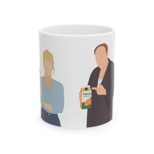 Puede incluir: Taza de cerámica blanca con una ilustración de dibujos animados de dos figuras, una de las cuales sostiene un cartón de zumo de naranja Tropicana. La taza tiene un acabado brillante y un asa estándar.