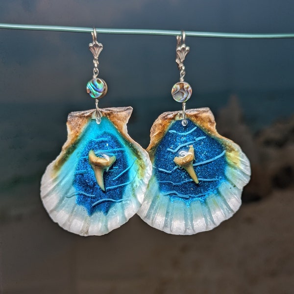 Seashell earrings with 3 layers of resin and real shark teeth wire wrapped to lever back ear wires ocean beach theme