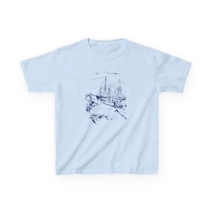 A light blue t-shirt with a navy blue illustration of a ship docked at a pier Sailboats Baby Tee, Seashell Baby Tee, Nautical Baby Tee, Nautical T-Shirt, Ocean Theme Crop Tee, Beach Day Crop Top, Summer Baby Tee