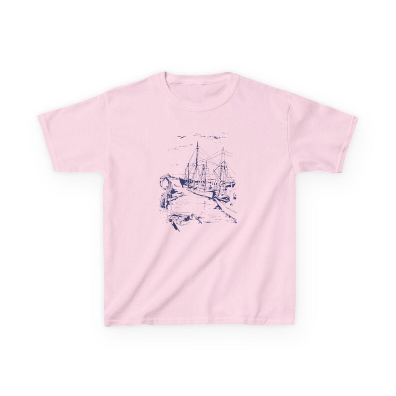 A pink t-shirt with a blue and white illustration of a ship docked at a pier. Sailboats Baby Tee, Seashell Baby Tee, Nautical Baby Tee, Nautical T-Shirt, Ocean Theme Crop Tee, Beach Day Crop Top, Summer Baby Tee