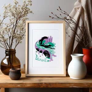 Può includere: Una stampa incorniciata di un'illustrazione viola e verde di un castello con un drago e il testo "Dawnesil 06". La stampa è in una cornice di legno e si trova su un tavolo di legno con un vaso di fiori e altri due vasi.