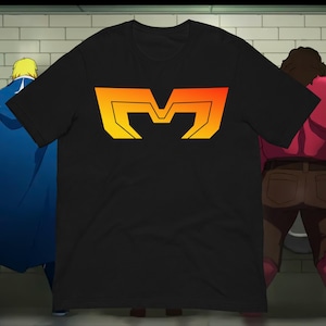 May include: Black t-shirt featuring a stylized, gradient orange and yellow letter "M" design. The graphic is centered on the front of the shirt. The shirt is a short-sleeved crew neck.