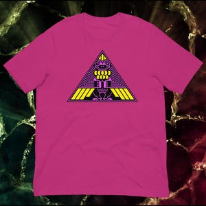 May include: A magenta t-shirt featuring a geometric design. The design includes a black figure within a yellow and purple triangle. The shirt is made of a soft material and has short sleeves.