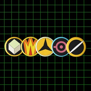 Peut inclure: Cinq badges ronds et colorés avec divers motifs géométriques. Les boutons sont jaunes, orange, noirs et bleus, sur un fond de grille noire. Chaque bouton présente un graphisme unique, dont un cube, un "W" stylisé et une étoile.