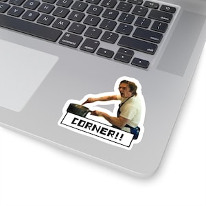 May include: A sticker featuring a man in a white shirt and blue apron stirring a pot with the text "CORNER!!" in black.