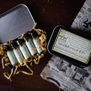 Puede incluir: Un conjunto de viales de 1,5 ml de muestras de aceite de perfume en una caja de hojalata. Los viales están etiquetados con nombres inspirados en las obras de Edgar Allan Poe, como "A Midnight Dreary", "Lost Lenore" y "Agony or Desire".