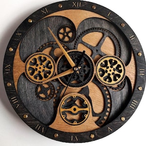 May include: A round wooden clock with a steampunk design. The clock features a dark gray and natural wood color scheme, with visible gears and Roman numerals. The clock hands are a light brown color, and the clock is accented with small brass studs.