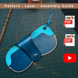 Könnte beinhalten: Eine handgefertigte Ledertasche in Blautönen mit einem kontrastierenden türkisfarbenen Innenraum. Die Tasche wird mit einem Druckknopfverschluss und einer Lederschlaufe verschlossen. Das Bild enthält den Text "Pattern • Laser • Assembly Guide" und PDF- und DXF-Symbole.