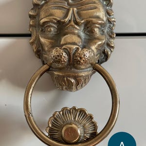 Batedor de porta antigo em latão com cabeça de leão: design vintage francês
