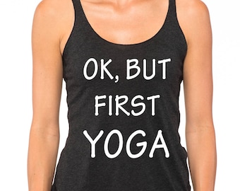 May include: Dark gray tank top with the text "OK, BUT FIRST YOGA" in white. The top has a racerback design and is made of a soft, comfortable material. Ideal for yoga and fitness activities.