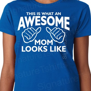 May include: A royal blue t-shirt with white text that reads "This is what an awesome mom looks like" with two thumbs up symbols.