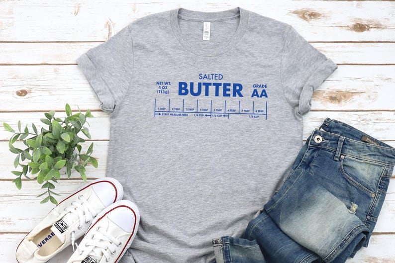May include: Gray t-shirt with blue text that reads "Salted Butter Grade AA" and a graphic of a stick of butter with measurements in tablespoons and cups.