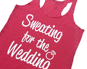 May include: Pink tank top with the text "Sweating for the Wedding" in white with a white diamond ring graphic.