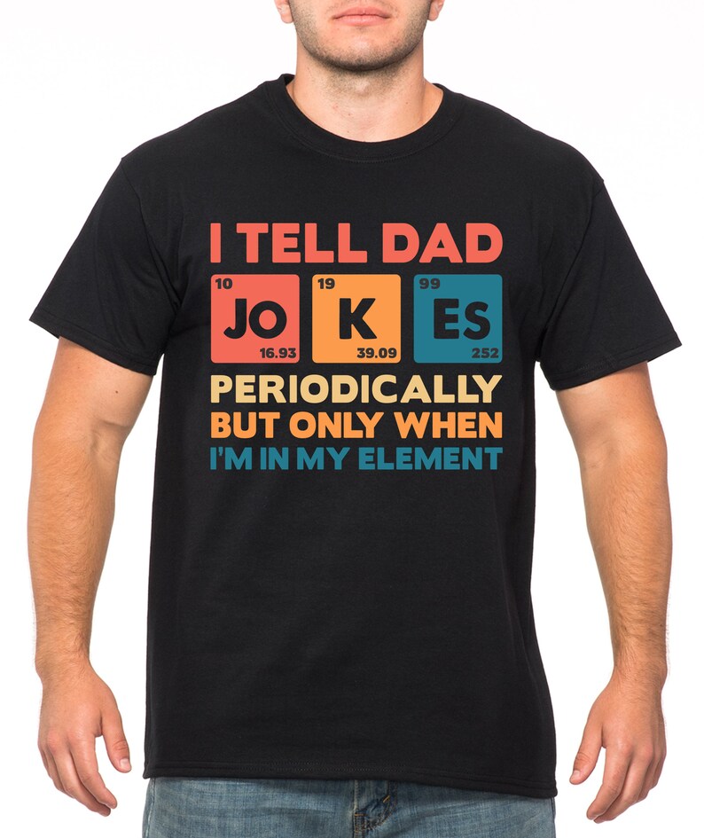 Puede incluir: Camiseta negra con el texto "I TELL DAD JOKES PERIODICALLY BUT ONLY WHEN I'M IN MY ELEMENT." El texto est&aacute; en un dise&ntilde;o colorido, con la palabra "JOKES" estilizada como elementos de la tabla peri&oacute;dica.