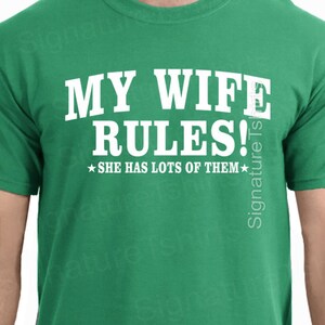 May include: Green t-shirt with white text that reads "MY WIFE RULES!  ★SHE HAS LOTS OF THEM★"