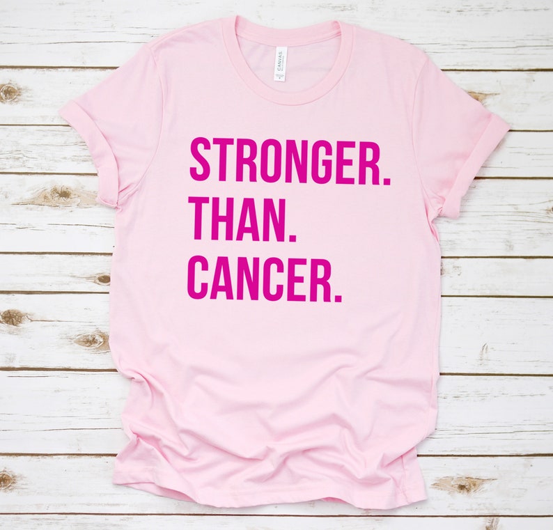 May include: Pink t-shirt with the text "STRONGER. THAN. CANCER." in hot pink.