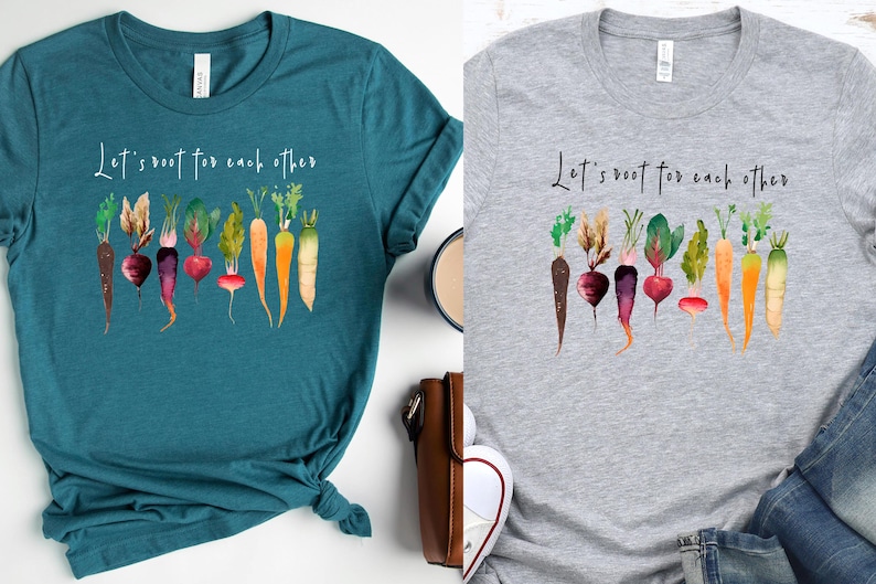 May include: Two t-shirts with a watercolor design of vegetables and the text "Let's root for each other". The shirts are teal and gray.