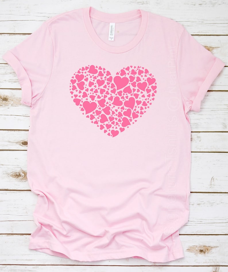 K&ouml;nnte beinhalten: Pinkes T-Shirt mit einem gro&szlig;en pinkfarbenen Herzdesign aus kleineren Herzen.