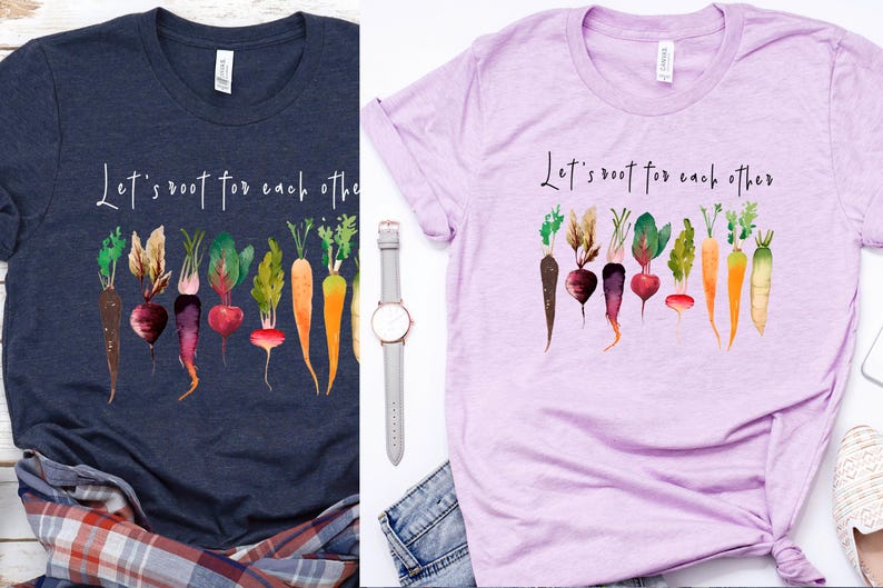 May include: Two t-shirts with the text "Let's root for each other" and a watercolor illustration of a row of carrots and beets. The shirts are navy blue and light purple.