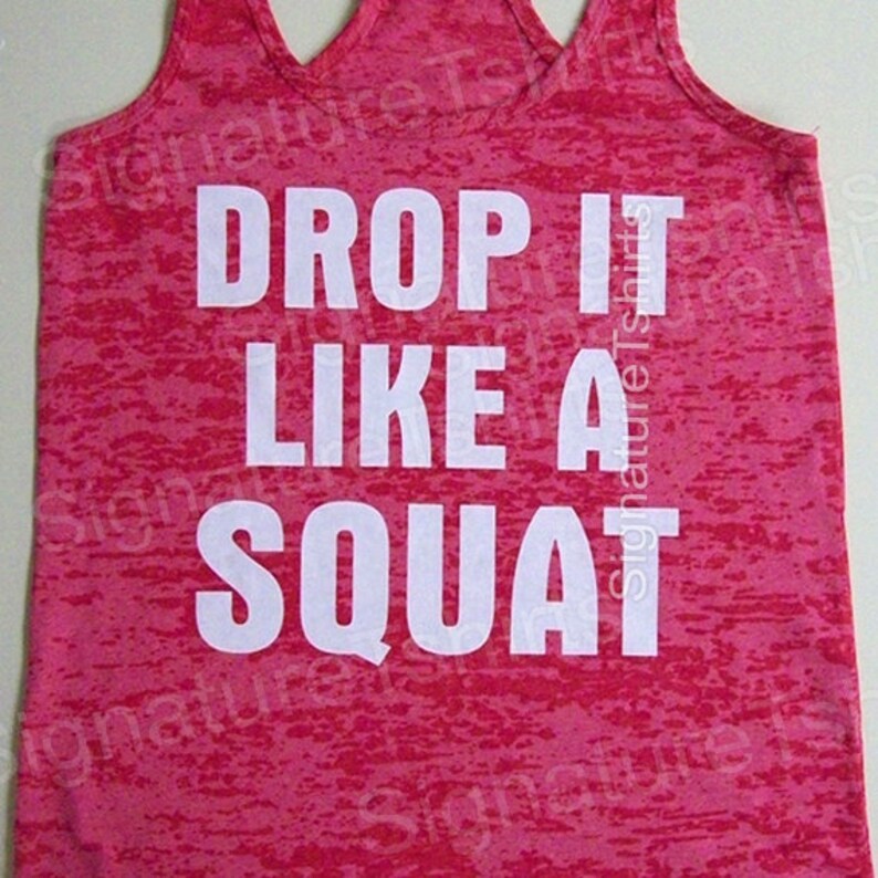 Może przedstawiać: R&oacute;żowa koszulka na ramiączkach z białym nadrukiem "Drop it like a squat".