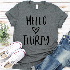 May include: A heather gray t-shirt with the text "Hello Thirty" in black lettering with a heart symbol between the words.