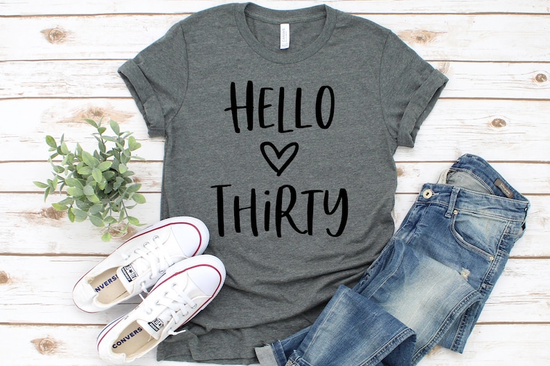 May include: A heather gray t-shirt with the text "Hello Thirty" in black lettering with a heart symbol between the words.