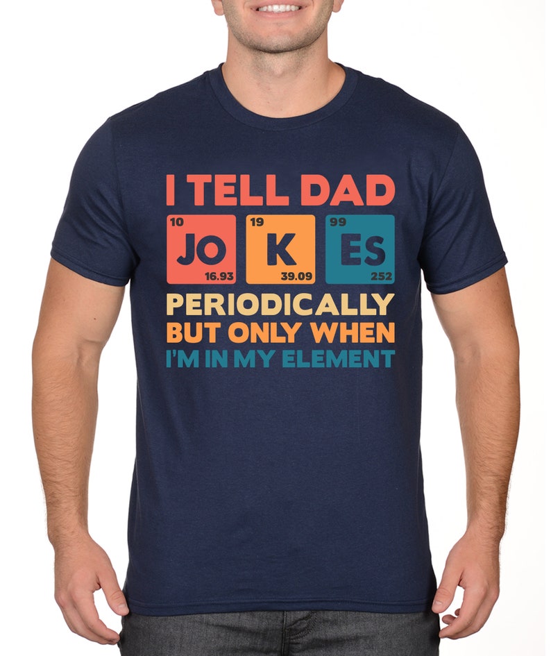 Puede incluir: Camiseta azul marino con el texto "I TELL DAD JOKES PERIODICALLY BUT ONLY WHEN I'M IN MY ELEMENT" en un dise&ntilde;o colorido de tabla peri&oacute;dica. La camiseta presenta los elementos Jo, K y Es. Una camiseta divertida con tem&aacute;tica cient&iacute;fica.