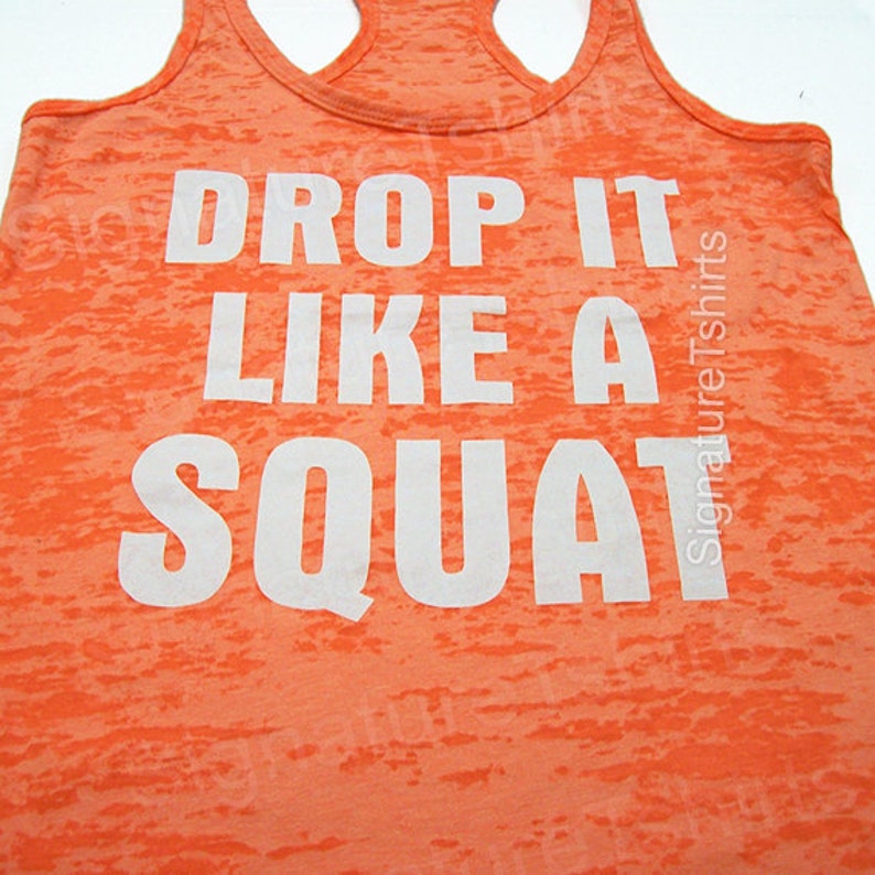 Może przedstawiać: Pomarańczowa koszulka na ramiączkach z białym nadrukiem "Drop it like a squat".