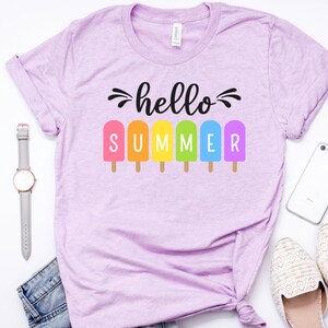 May include: A light purple t-shirt with the text "hello summer" and a row of colorful popsicles.