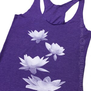 May include: Purple tank top with a white floral design. The design features four white lotus flowers.