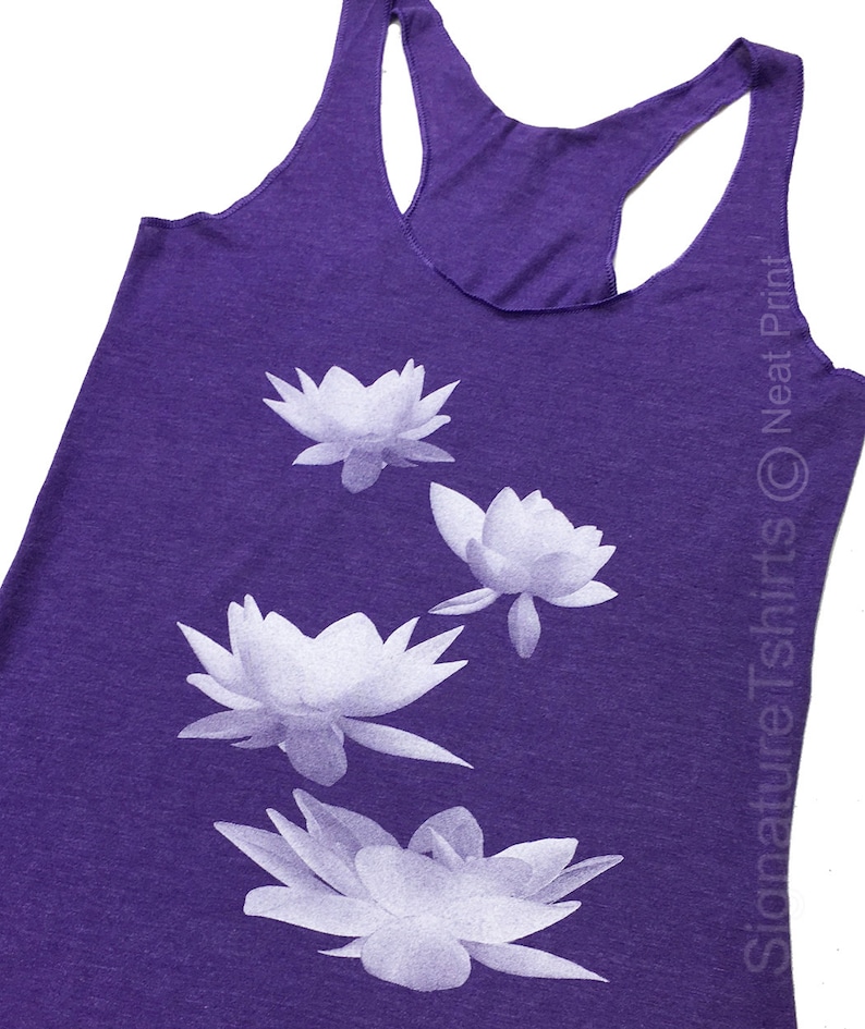 May include: Purple tank top with a white floral design. The design features four white lotus flowers.